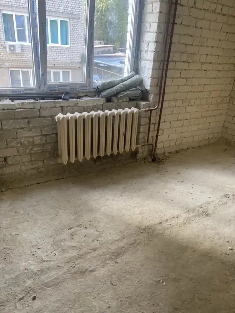 Монтаж чугунного радиатора и стояков отопления в помещении с необработанными стенами - этап черновых работ