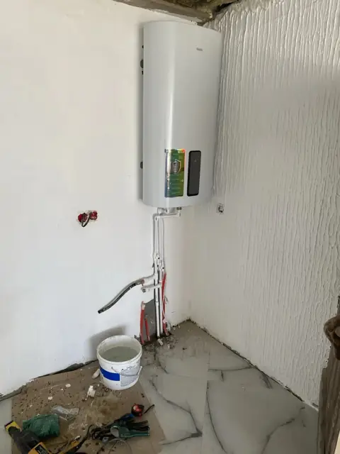 Подключение водонагревателя Haier - трубы, инструмент и вёдро на объекте
